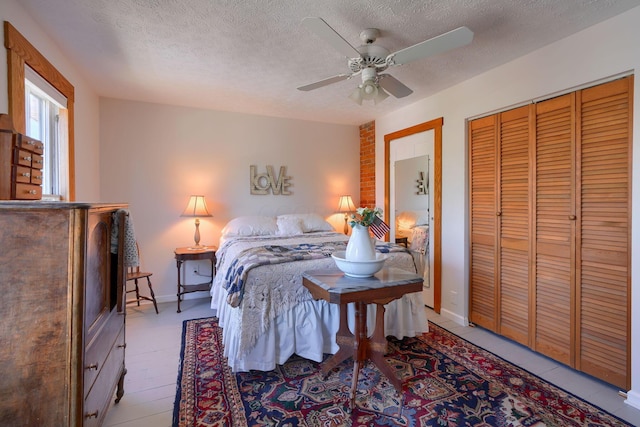 bedroom with a ceiling fan, a textured ceiling, baseboards, and a closet