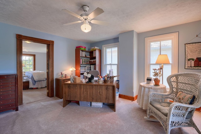 carpeted office featuring a ceiling fan and a textured ceiling