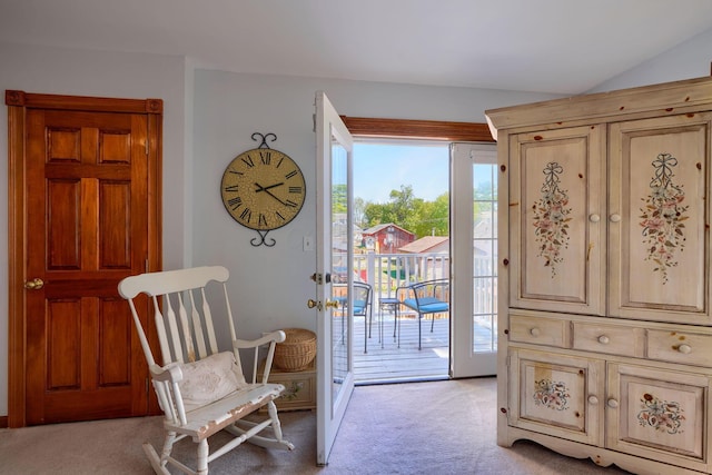 doorway to outside featuring light colored carpet and vaulted ceiling