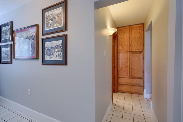 hallway with baseboards and light tile patterned floors