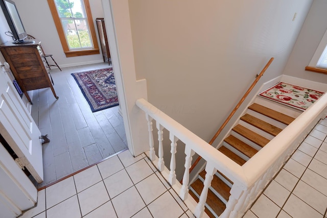 staircase featuring baseboards and tile patterned flooring