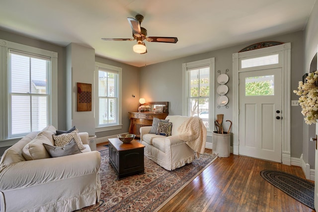 living area featuring baseboards, ceiling fan, and hardwood / wood-style flooring