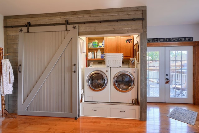 washroom featuring a healthy amount of sunlight, separate washer and dryer, light wood-style flooring, and cabinet space