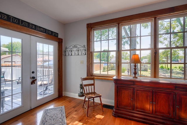 doorway with baseboards, visible vents, french doors, and light wood finished floors