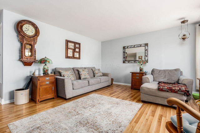 living area with baseboards and wood finished floors