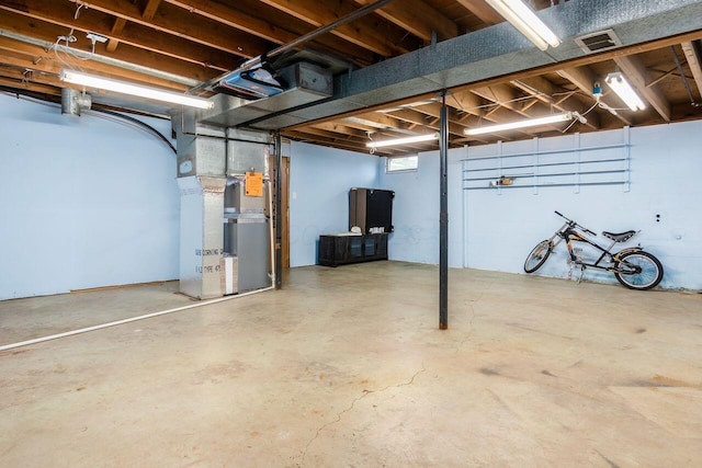 basement featuring visible vents and heating unit