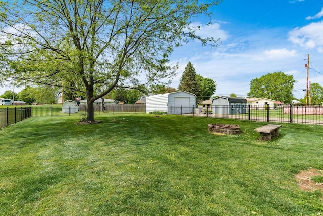 view of yard featuring a fenced backyard, an outbuilding, and a garage