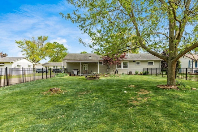 rear view of property with a lawn and a fenced backyard