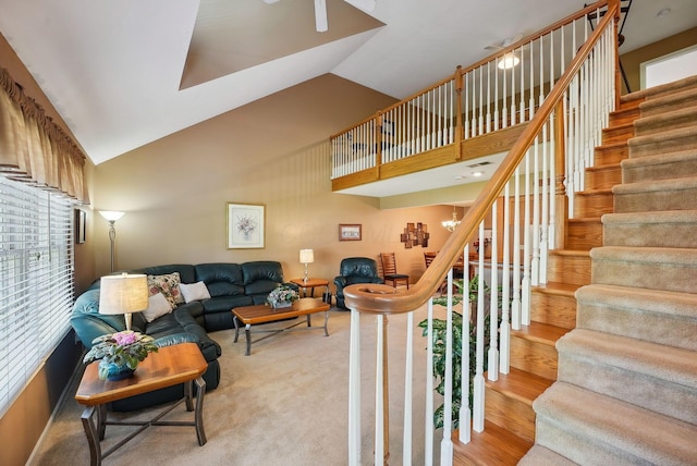 living area featuring high vaulted ceiling, wood finished floors, and stairway