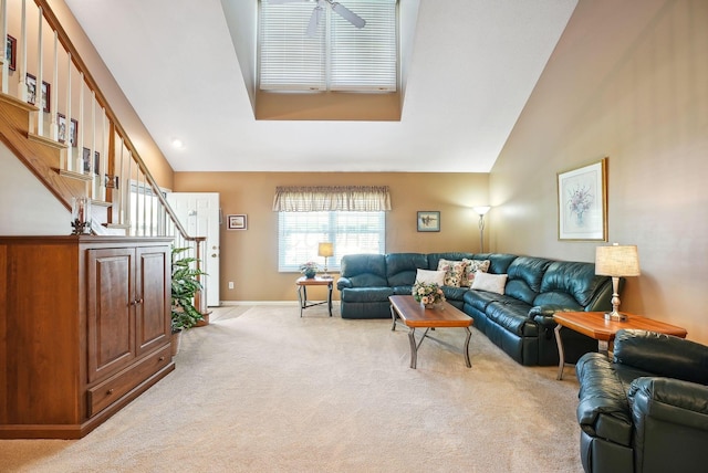 living room with high vaulted ceiling, light carpet, baseboards, and stairway