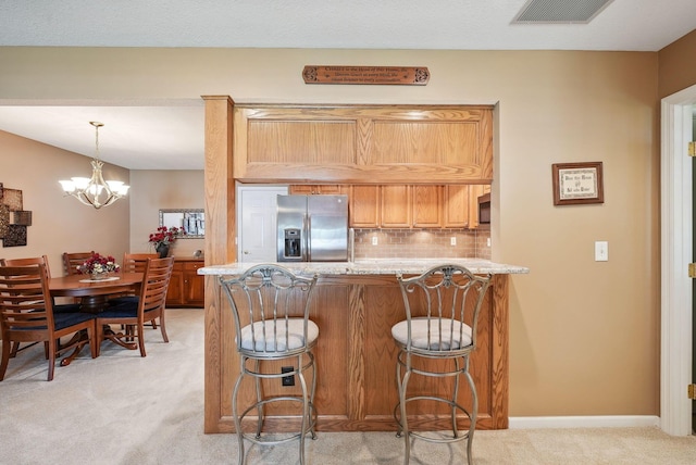 kitchen featuring light colored carpet, stainless steel fridge with ice dispenser, a peninsula, tasteful backsplash, and visible vents