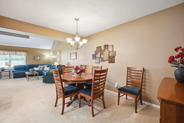 dining space with baseboards, a notable chandelier, light carpet, and lofted ceiling
