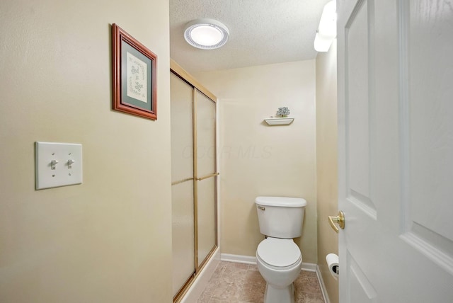 full bathroom with baseboards, a textured ceiling, a stall shower, and toilet