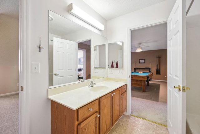 ensuite bathroom featuring a ceiling fan, pool table, baseboards, vanity, and ensuite bathroom