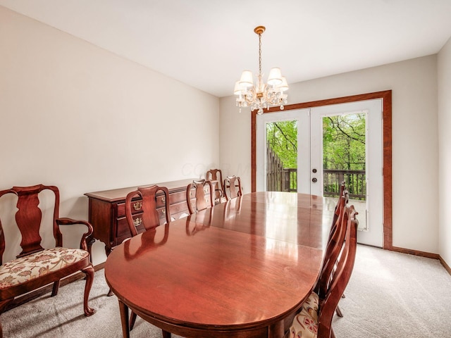 dining area featuring baseboards, french doors, a chandelier, and light colored carpet