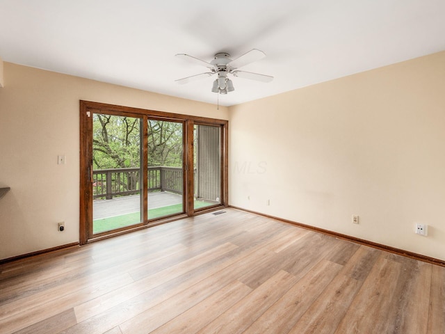 empty room featuring baseboards, a ceiling fan, light wood-style flooring, and visible vents