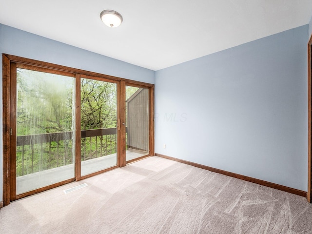 unfurnished room featuring visible vents, baseboards, and light colored carpet