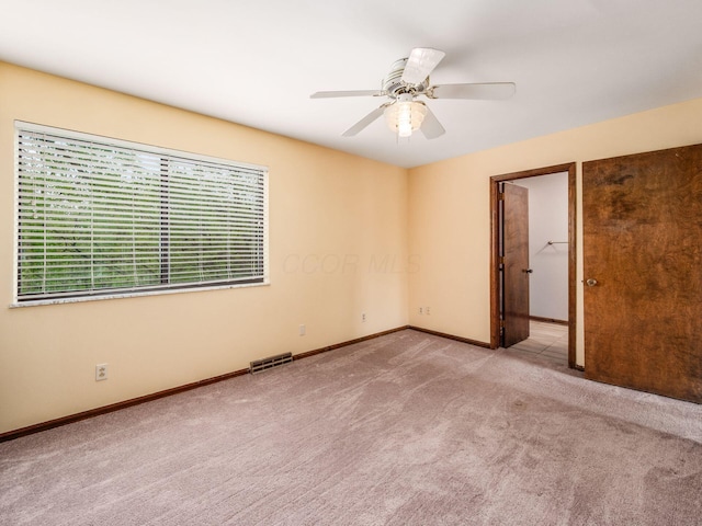 spare room featuring visible vents, carpet flooring, baseboards, and a ceiling fan