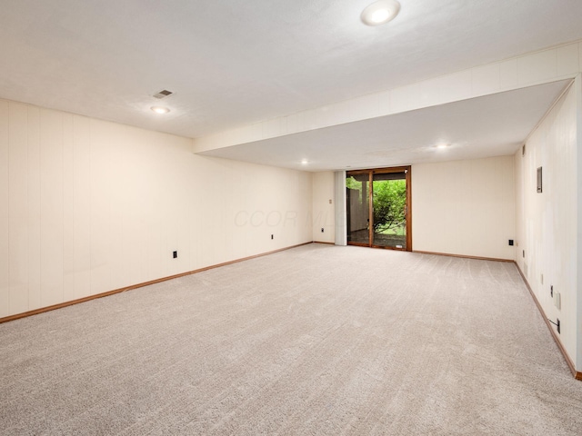 spare room featuring light colored carpet, baseboards, and visible vents
