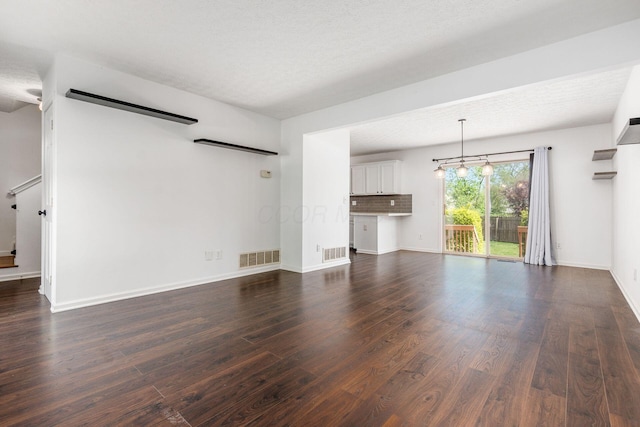 unfurnished living room with stairway, baseboards, dark wood-style floors, and visible vents