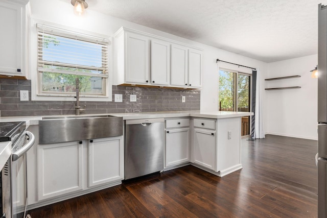 kitchen with light countertops, appliances with stainless steel finishes, dark wood-style floors, and a sink