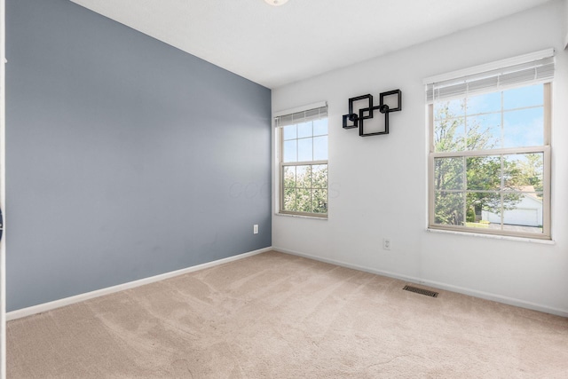 unfurnished room featuring carpet floors, baseboards, and visible vents