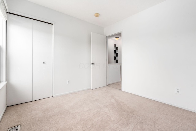 unfurnished bedroom with visible vents, baseboards, carpet floors, and a closet