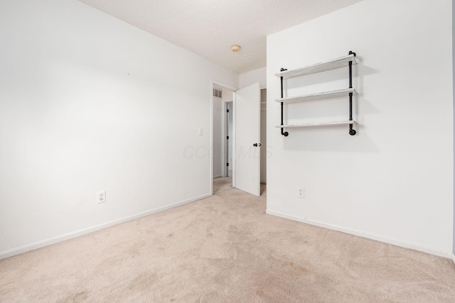 unfurnished bedroom with baseboards, carpet, and visible vents