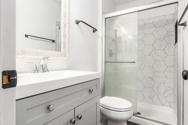full bath with vanity, a shower stall, and toilet