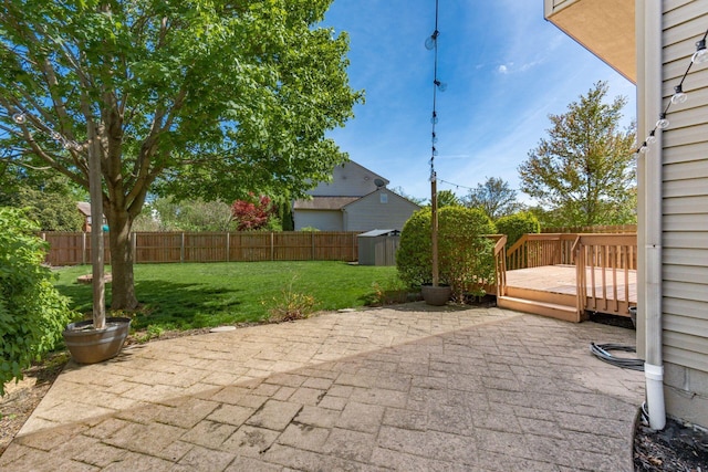view of patio / terrace featuring a fenced backyard, an outbuilding, a storage shed, and a deck