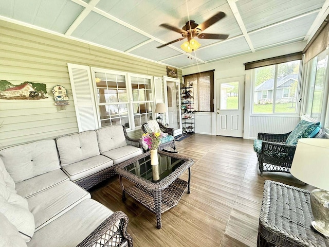 sunroom / solarium with a ceiling fan, an outdoor living space, and beam ceiling