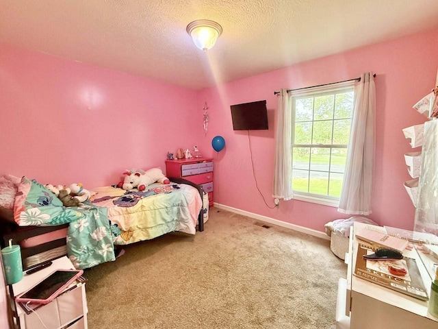 carpeted bedroom featuring baseboards, a textured ceiling, and visible vents