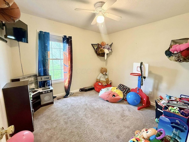 rec room featuring baseboards, a ceiling fan, and carpet