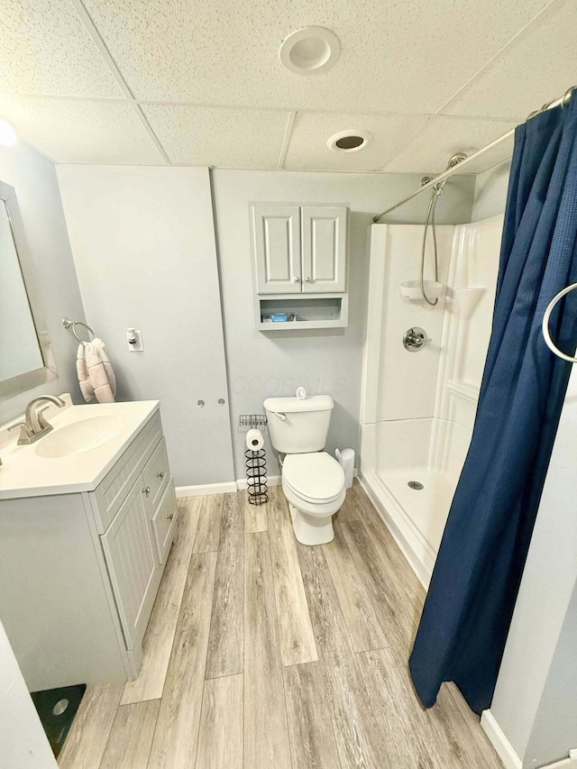 full bath with vanity, wood finished floors, toilet, a shower with shower curtain, and a drop ceiling