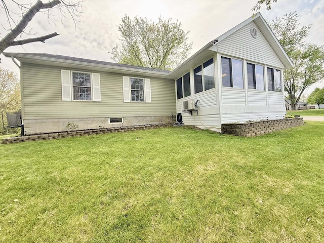 rear view of house with a yard and a sunroom