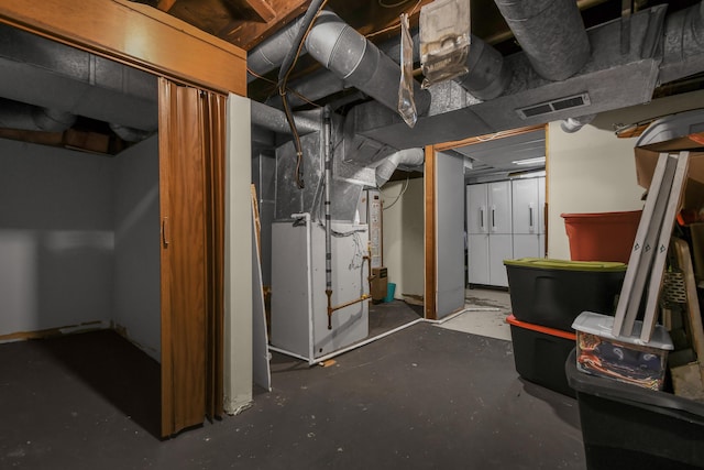 unfinished basement featuring visible vents and heating unit