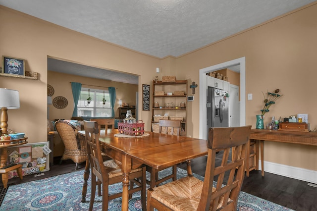 dining area featuring a textured ceiling and dark wood finished floors
