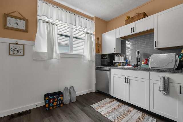 kitchen featuring stainless steel dishwasher, visible vents, dark wood-style floors, a sink, and backsplash