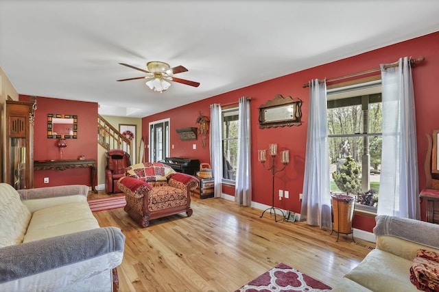 3615 Dragoo Rd, Nashport, OH 43830 - living room with stairway, ceiling fan, light wood-style floors, and a wealth of natural light
