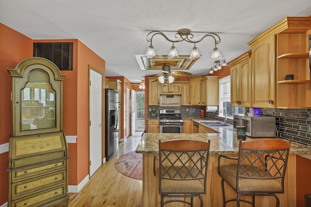 3615 Dragoo Rd, Nashport, OH 43830 - kitchen with visible vents, a peninsula, a sink, backsplash, and stainless steel appliances