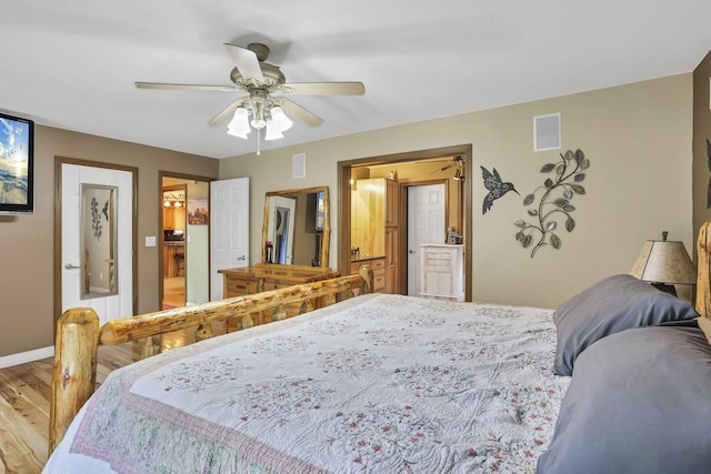 3615 Dragoo Rd, Nashport, OH 43830 - bedroom with a ceiling fan, visible vents, wood finished floors, baseboards, and connected bathroom