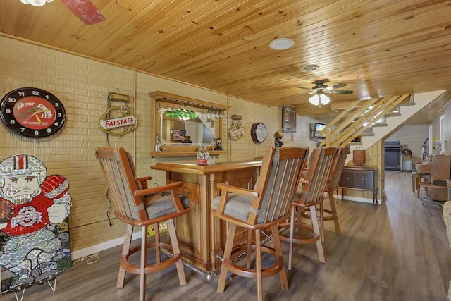 3615 Dragoo Rd, Nashport, OH 43830 - dining room featuring a ceiling fan, wood finished floors, brick wall, wood ceiling, and a dry bar