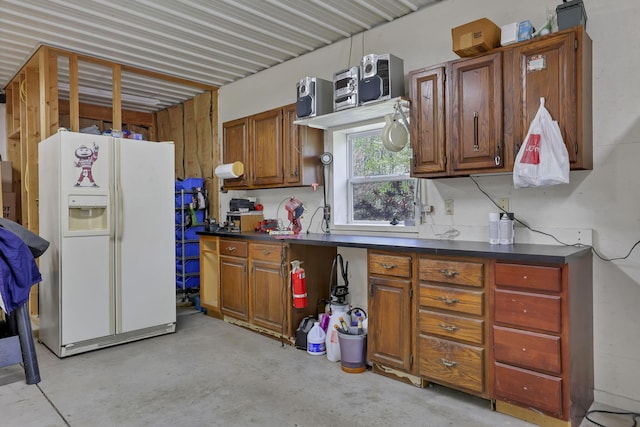 3615 Dragoo Rd, Nashport, OH 43830 - kitchen featuring concrete flooring, brown cabinets, white refrigerator with ice dispenser, and dark countertops