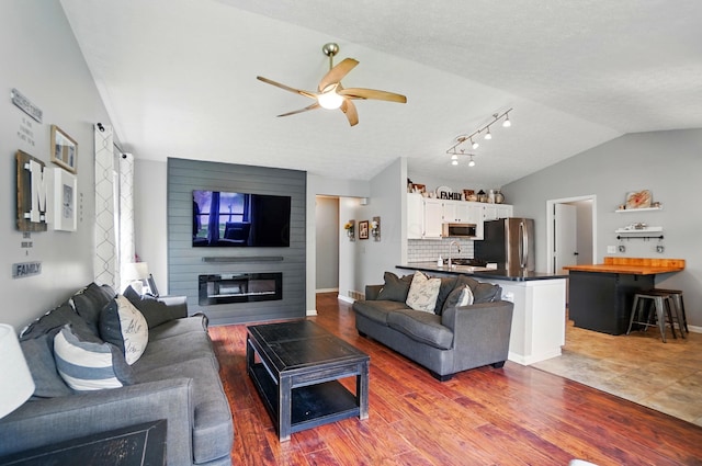 4969 Shannonbrook Dr, Columbus, OH 43221 - living area featuring wood finished floors, a fireplace, baseboards, a ceiling fan, and vaulted ceiling