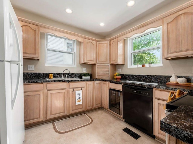 121 Haldy Ave, Columbus, OH 43204 - kitchen with dishwasher, freestanding refrigerator, light brown cabinetry, a sink, and dark stone countertops