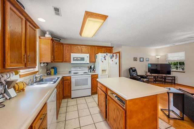 kitchen with visible vents, white appliances, open floor plan, light countertops, and a sink
