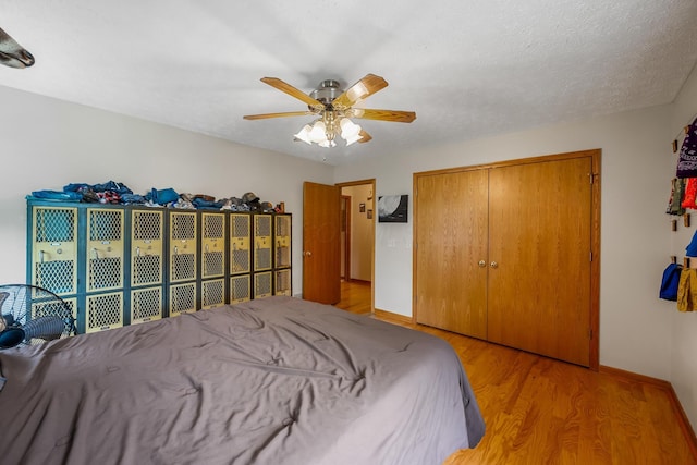 bedroom with a ceiling fan, baseboards, wood finished floors, and a closet
