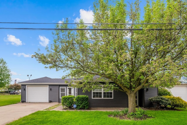 view of front of property with concrete driveway, an attached garage, and a front yard