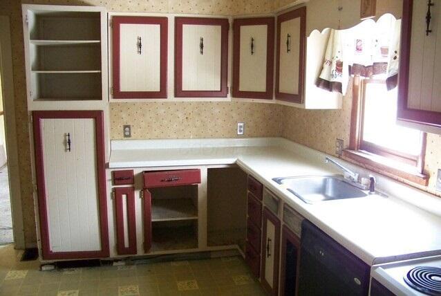 kitchen with black dishwasher, electric stove, wallpapered walls, light countertops, and a sink