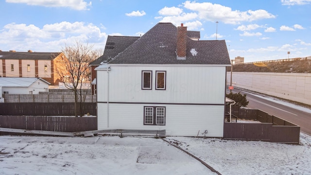502 Hamilton Ave, Columbus, OH 43203 - snow covered back of property featuring a chimney, a shingled roof, and a fenced backyard